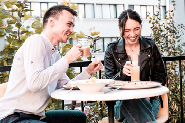 Happy young couple having lunch at outdoors restaurant