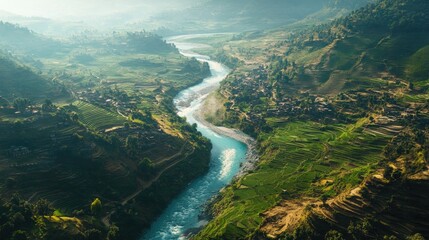 A breathtaking aerial view of a South Asian river winding through a valley, with terraced fields on either side.