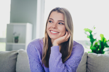 Photo of attractive young woman sit couch look empty space dreamy dressed purple outfit cozy day light home interior living room