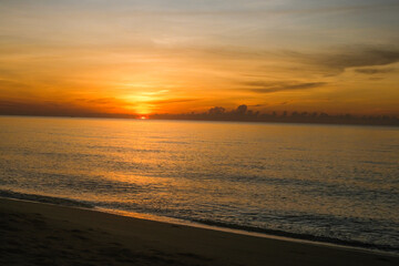 The sun rises at the sea in the morning.