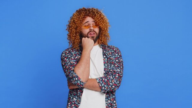 Caucasian man tired bored indifferent expression, exhausted of tedious story, not interested in communication talk, displeasure, uninteresting. Stylish young guy isolated on studio blue background