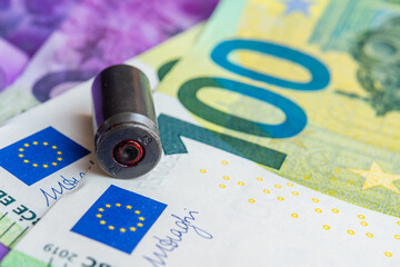 The empty shell of the bullet lies on the money of Europe. The concept of Ukraine defense war financing. Help to Ukraine from the EU.