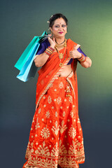 Indian Traditional woman holding and posing with shopping bags and showing somthing with hand