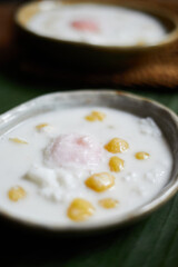 Thai glutinous rice balls with coconut milk on wood