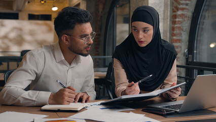 Two business colleagues muslim islamic businesswoman in hijab Arabian businessman working with...