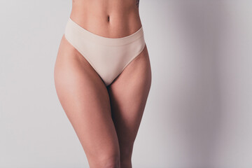 Cropped photo of pretty young girl hips legs model dressed stylish white underwear no filter isolated on gray color background