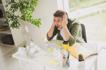 Photo of glad crazy excited successful man assistant sitting chair working workstation workspace...