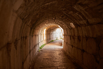 Obraz premium Travel, tunnel and ancient architecture in Greece as old building, structure and history at destination. Landmark, monument and empire with tourism, culture and art for discovery, adventure and site