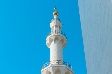 Obraz premium A mosque minaret against clear blue sky with copy space on left side