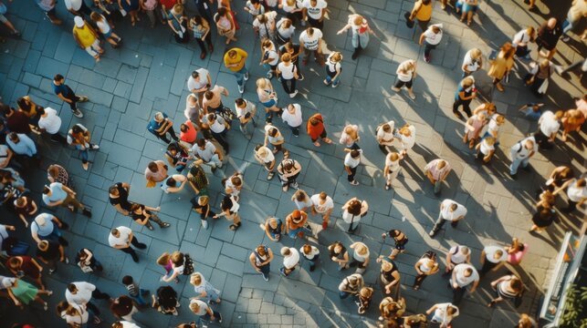 An overhead view of a lively crowd gathered in a bustling city square under bright sunlight, people engaging in various activities and enjoying their time.