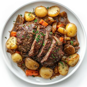 A plate full of slow cooked beef, potatoes, carrots, onions, and a rich brown sauce.