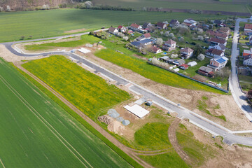 Aerial view of construction site with new roads. Family houses as example of real estate development in suburbs.  Construction of residential houses in the microdistricts. Space for text. Cityscape