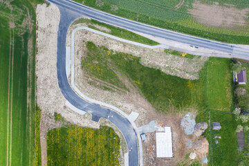 Aerial view of construction site with new roads. Family houses as example of real estate development in suburbs.  Construction of residential houses in the microdistricts. Space for text. Cityscape