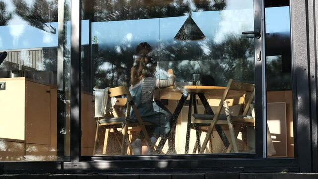 Two young children sharing a meal in a modern home with large windows