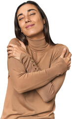 Hispanic young woman hugs, smiling carefree and happy.