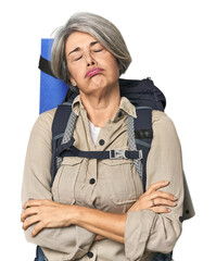 Caucasian mid-age female with hiking gear tired of a repetitive task.