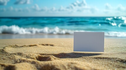 tropical beach scene, blank white card on sand, turquoise ocean waves, clear blue sky, copy space for text, golden sand, sunny day, seaside atmosphere.