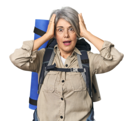 Caucasian mid-age female with hiking gear screaming, very excited, passionate, satisfied with something.