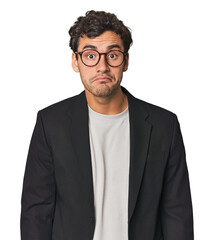 Young Hispanic businessman shrugs shoulders and open eyes confused.