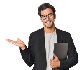 Fototapeta na wymiar Young Hispanic businessman with laptop showing a copy space on a palm and holding another hand on waist.