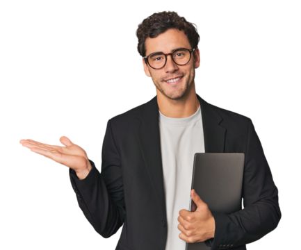Young Hispanic businessman with laptop showing a copy space on a palm and holding another hand on waist. - Powered by Adobe