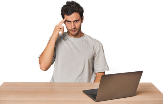Hispanic young man working on laptop pointing temple with finger, thinking, focused on a task.