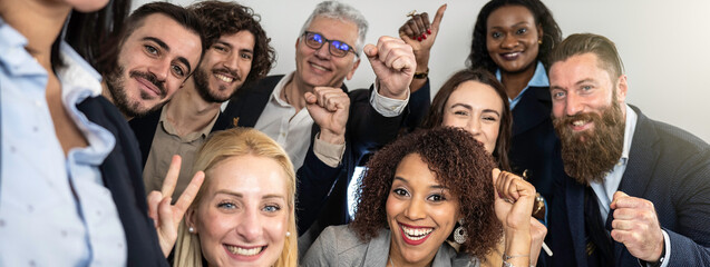 Horizontal banner or header with excited business team celebrating together with smiles and raised fists, capturing the energy of a successful collaboration.