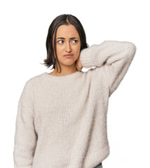 Young Caucasian woman with short hair touching back of head, thinking and making a choice.