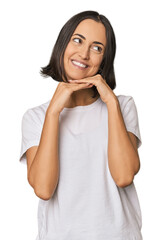 Young Caucasian woman with short hair keeps hands under chin, is looking happily aside.