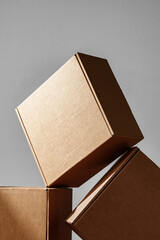 Three Cardboard Boxes Stacked on a Wooden Surface in a Room With Natural Light