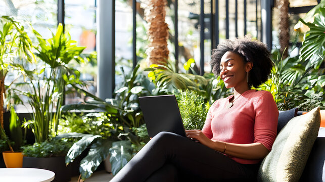 Content Employee Relaxing in Spacious Break Room, Surrounded by Comfortable Seating and Greenery.