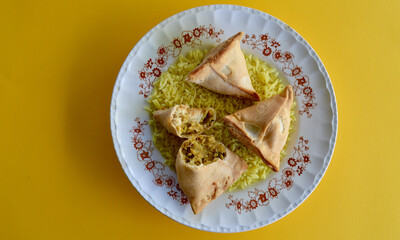 Samosas on a bed of saffron rice.