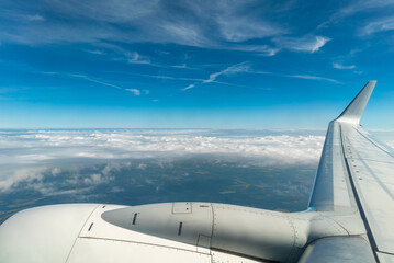 View from a Flying Airplane of Engine and Wing with Clouds Below