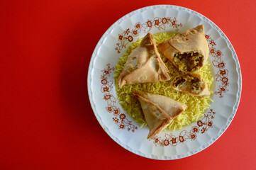 Samosas on a bed of saffron rice.