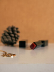 Female accessories. Composition with a red lipstick and a necklace. Autumn, fall mockup.