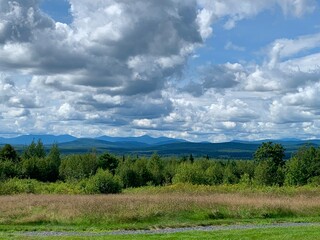 Obraz premium Sweeping view of Maine mountains and green fields in late summer. 