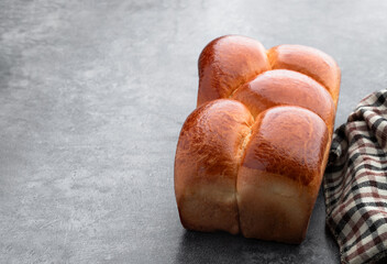 Braided wheat flour loaf on gray background