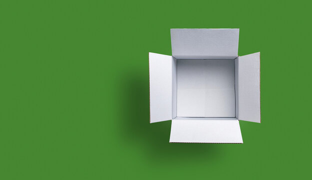 White square cardboard box, opened and viewed from above. isolated on green background.