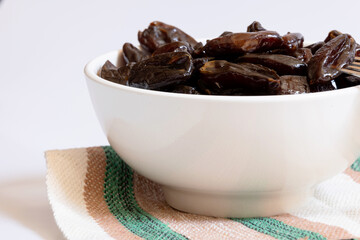 Portion of dried dates in a bowl photographed close up