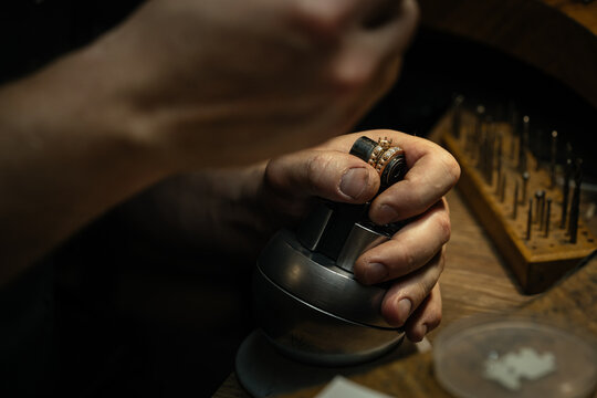 Jeweler puts diamond to golden wedding luxury ring.