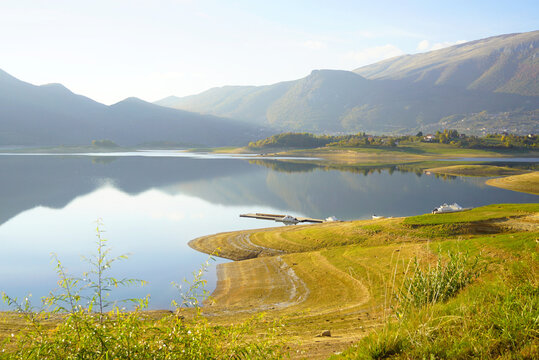 Rama Lake, photographed during a trip to the most beautiful places in Bosnia and Herzegovina. Autumn landscape with sunlit mountains, picturesque winding shore and mirror-like waters of Ramsko jezero