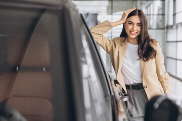 Obraz premium Woman, portrait and smile at car dealership with sale, payment and purchase of new motor. Shopping, customer with pride from deal and investment of vehicle at showroom and store