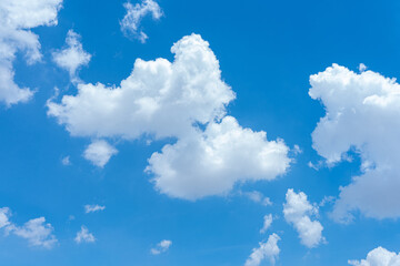 Bright blue sky with fluffy white clouds on a sunny day