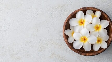 Top view of frangipani flowers in a wooden bowl on a textured surface, Tropical Zen, calming retreat