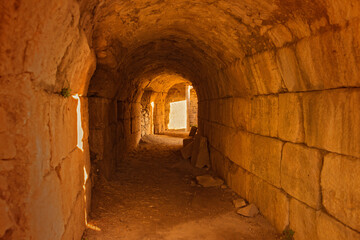 Fototapeta premium Greece, wall and tunnel in ruins for architecture, archeology and travel to ancient city. History, rock and path in abandoned Greek theater for exploration, culture and anthropology in Miletus