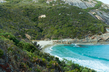 Turquoise waters meet pristine white sand at a secluded beach in Western Australia. Rugged...