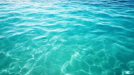 Obraz premium A close-up of the clear, turquoise ocean water with gentle ripples and reflections of sunlight.