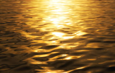 Beautiful sunlight reflection of gold water. surface​ gold​ water background. abstract golden textured background.