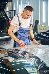 Master glues the protective film on the car