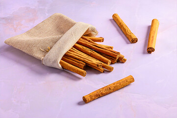 Jute Bag with Cinnamon Sticks on Light Marble